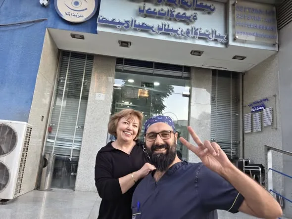 الدكتور باسل الجردي مع مريضة أمام مركز الإنتراليزك الدولي لطب العيون